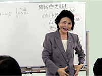 松本玲子先生がホワイトボードの前で説明しているアップ写真